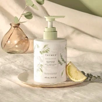 Thymes eucalyptus body lotion styled with eucalyptus on linen